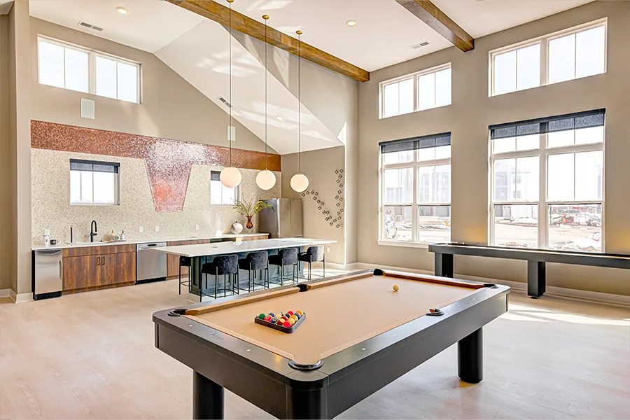 A community clubhouse, like this one at Crossing 5 Apartments, is a hub for amenities that let you work or hang out close to home. Seating and a pool table inside a stylish apartment clubhouse.