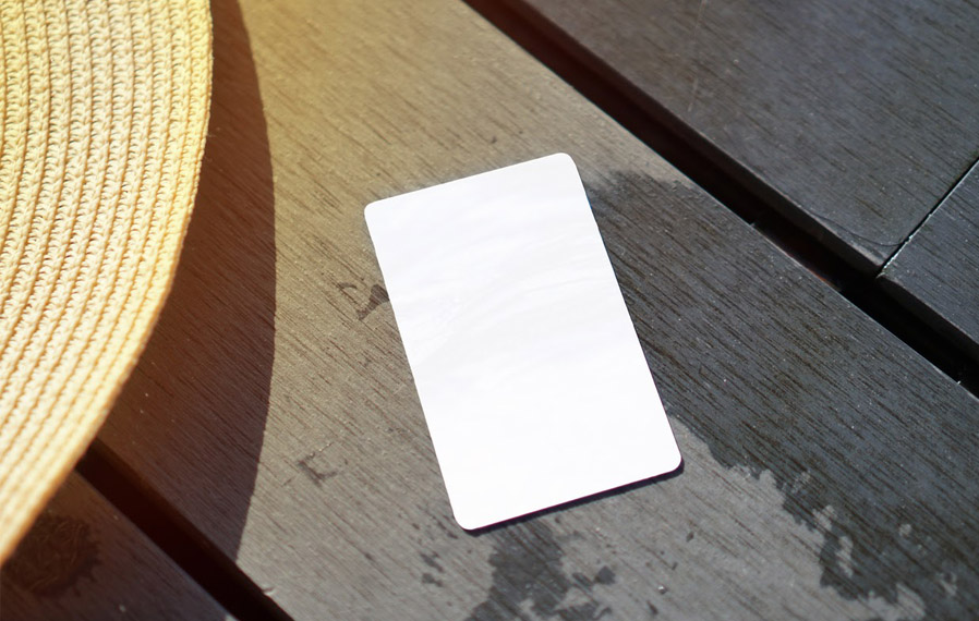 Don't forget your pool pass to to take a refreshing swim at The Legacy Towns and Flats. Summer hat and key card on a deck floor.