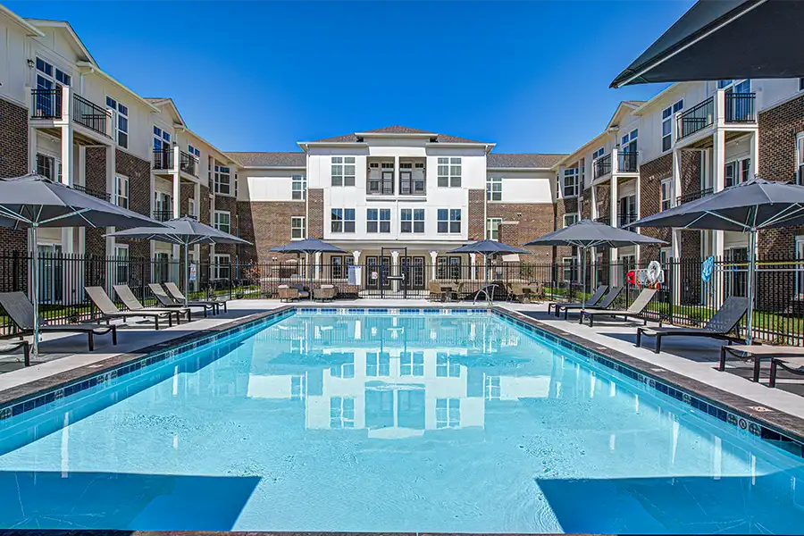 Pristine pool surrounded by apartment buildings at The Legacy Apartments.